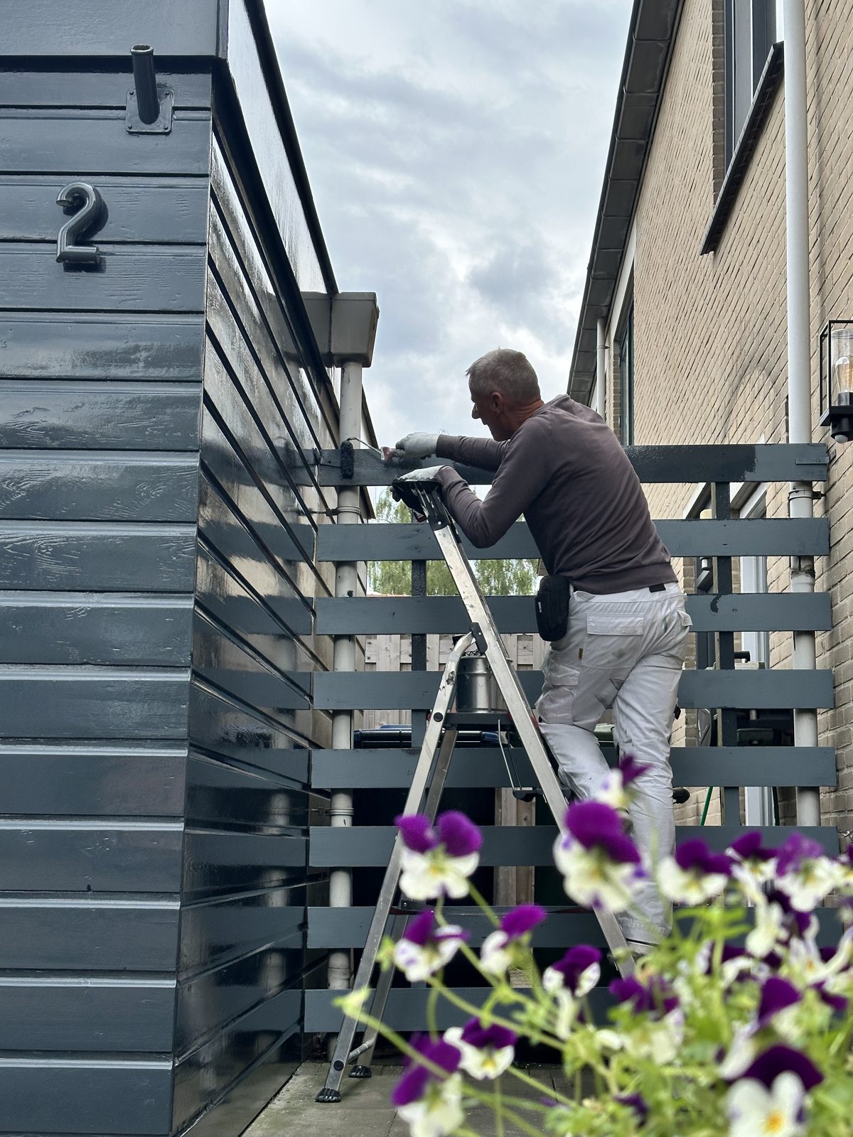 Garden fence painted in the same slate colour as the house
