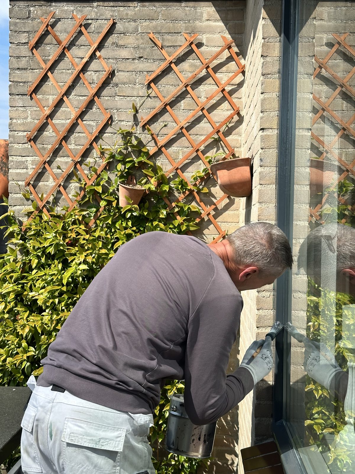Close-up of a brush painting a courtyard window frame